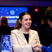 A grad shakes President Mantella's hand